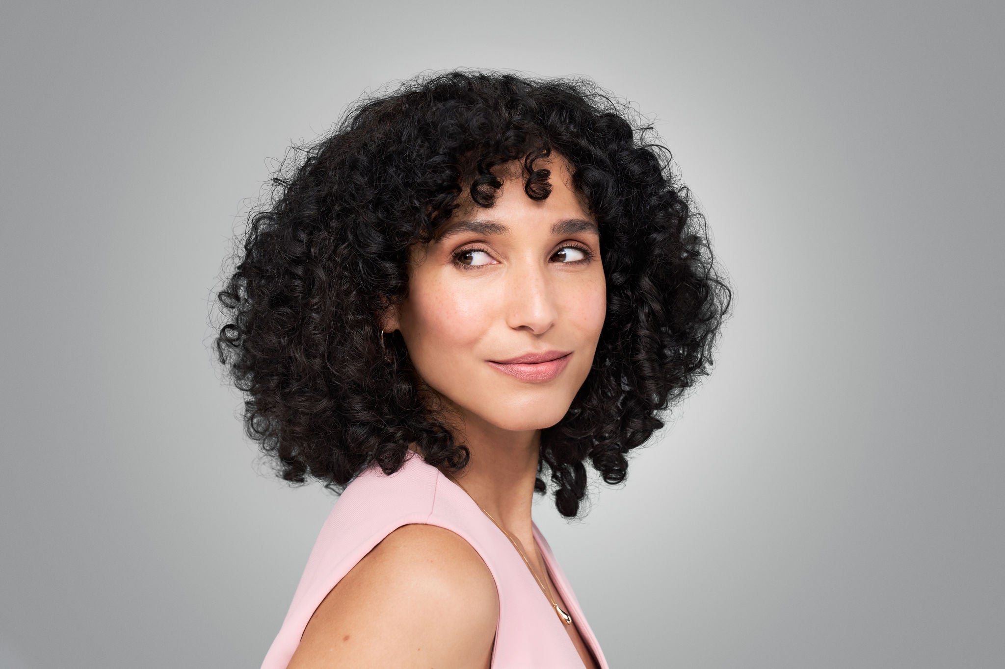 femme qui regarde son visage après injections d'acide hyaluronique de Juvederm une solution anti age