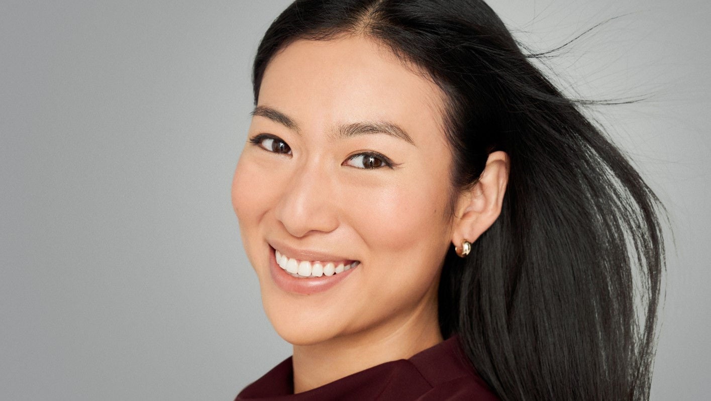 portrait d'une femme brune aux cheveux bouclés après injections d'acide hyaluronique de Juvederm